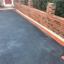 Tarmac driveway and brick wall